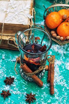 glass of mulled wine,old books and basket of ripe tangerines