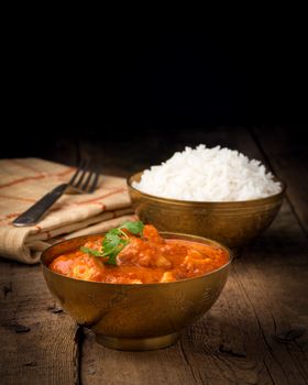 Indian butter chicken photographed with a low key background.