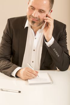 Close up of attractive man talking on the telephone white background