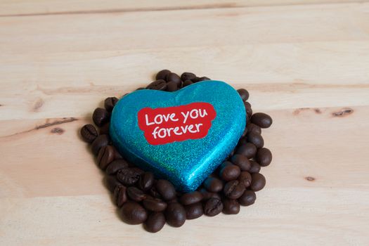 Coffee beans surrounded Chocolate wrapper on Valentine's Day, Wood background.