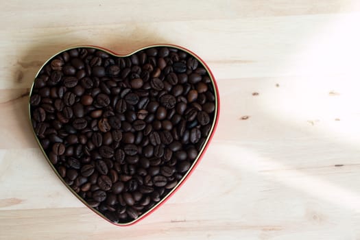 Coffee beans in the heart on Valentine's Day, Wood background.