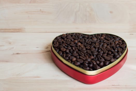 Coffee beans in the heart on Valentine's Day, Wood background.