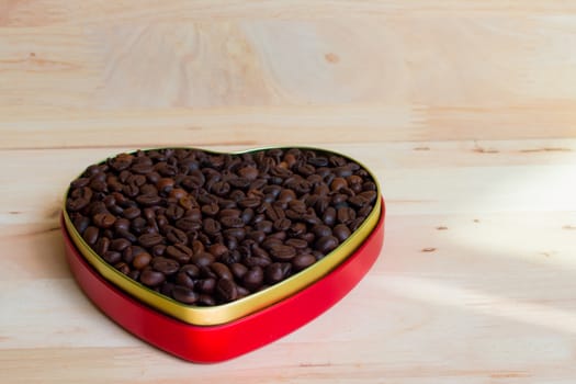 Coffee beans in the heart on Valentine's Day, Wood background.