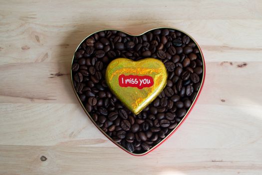 Coffee beans surrounded Chocolate wrapper on Valentine's Day, Wood background.