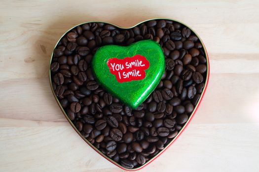 Coffee beans surrounded Chocolate wrapper on Valentine's Day, Wood background.