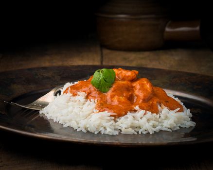 Indian butter chicken on a bed of rice photographed closeup.