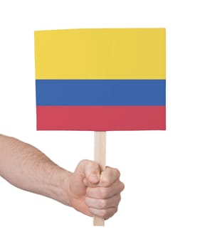 Hand holding small card, isolated on white - Flag of Colombia