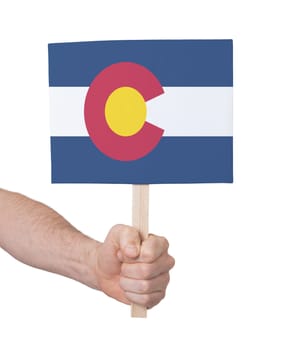 Hand holding small card, isolated on white - Flag of Colorado