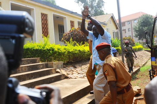 UGANDA, Kampala: David Sejusa flashes his handcuffs as he arrives at military court in Kampala, Uganda on February 9, 2016 where he would be denied bail as his case is adjourned until February 23. Sejusa was jailed after being charged the week previous with charges including absence without official leave, participating in partisan political activities, and insubordination.