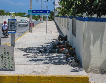 2008: Several Mexican workers take a break from their job to take a short nap in the shade on a hot summer day., Isla Mujeres, Mexico- June 23