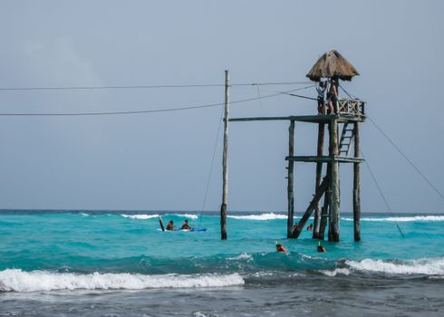 2008: A man enjoys the zip line over the ocean on the Isla Mujeres in Mexico., Isla Mujeres, Mexico- June 27