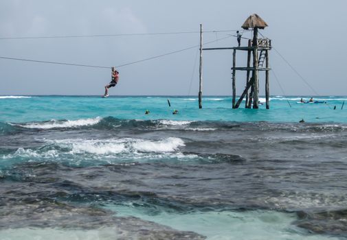 2008: A man enjoys the zip line over the ocean on the Isla Mujeres in Mexico., Isla Mujeres, Mexico- June 27