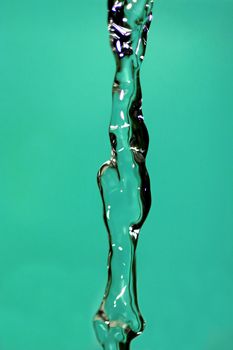 Water falling down, frozen in time with blue background.