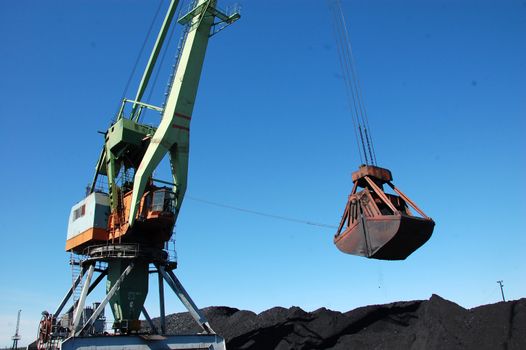 Dockside cargo craine loading coal at Kolyma river port, Zyryanka, Yakutia, Russia