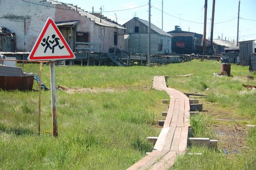 Children crossing warning road sign at rural area, Pokhodsk village, Yakutia region, Russia