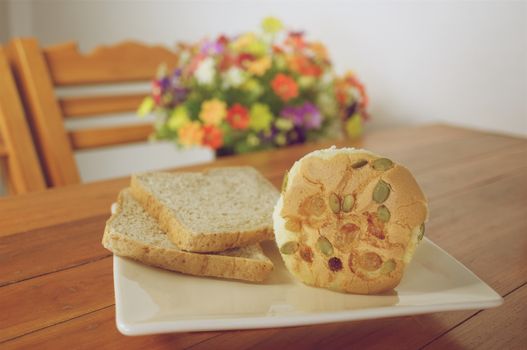 Cup cake with pumpkin seeds and currant place in plate with bread on wood table vintage style.