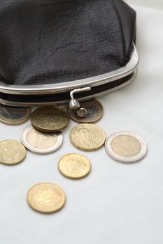 Vintage black leather wallet near coins on white background