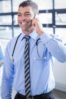 Happy doctor on the phone in the hospital