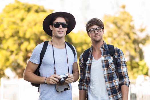 Hip men holding digital camera outdoors