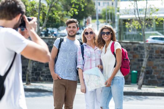 Hip man taking picture of his friends outdoors