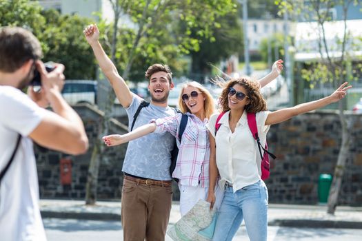 Hip man taking picture of his friends outdoors