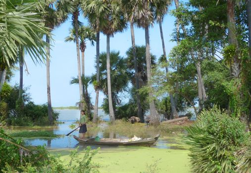 Young girl rowing a boat through a green landscape