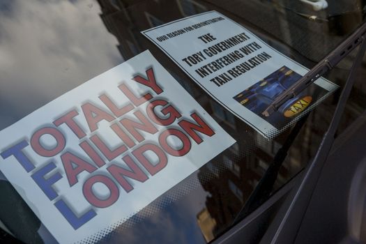 UNITED-KINGDOM, London: A picture is taken of a sign on a black cab saying Totally failing London as taxi drivers hold another protest under the hashtag #Blackcabprotest against competition from app-based taxi services, and especially US company Uber, on February 10, 2016. Since its introduction in Britain, drivers of the city's famous black cabs have argued Uber bypasses local licensing and safety laws and amounts to unfair competition. They have staged a number of high-profile protests, including go-slow demonstrations that have brought traffic in the centre of London from Trafalgar Square to Victoria street.
