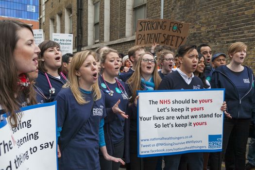 ENGLAND, London: Junior Doctors picket and hold signs during a demonstration outside Royal London Hospital on February 10, 2016, in London. The strike claim's the doctors would be over-worked which would lead to patients being endangered.  
