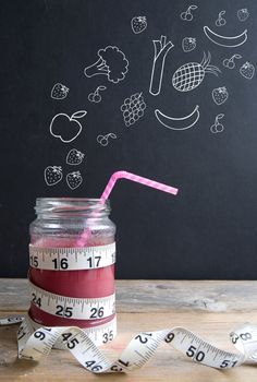 Berry smoothie with tape measure and fruits and vegetables appearing 'pouring in' sketched on a chalkboard