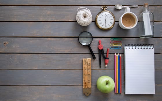 Various items, including stationery and vintage,  laid out on a wooden background