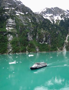 Tracy Arm, Alaska, USA- June 19, 2012: A small cruise ship with passengers on the deck admire the scenery in this lovely area of Tracy Arm in Alaska,
