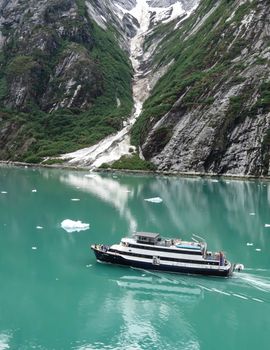 Tracy Arm, Alaska, USA- June 19, 2012: A small cruise ship with passengers on the deck admire the scenery in this lovely area of Tracy Arm in Alaska,