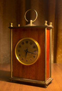 old table clock on a table in a warm light