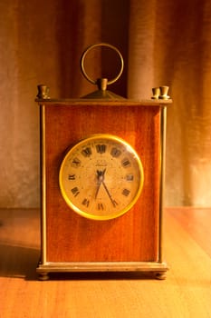 old table clock on a table in a warm light