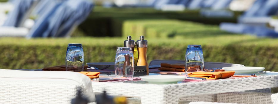 Crop of restaurant table on resort, panoramic view.