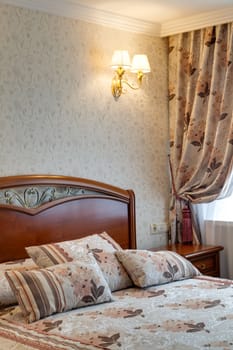 Bedroom in hotel with a big bed, a bedside table and a window