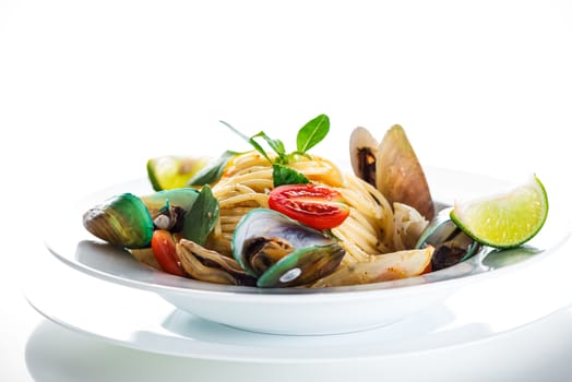 Fresh and spicy seafood pasta in white plate on white background