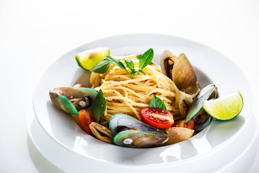 Fresh and spicy seafood pasta in white plate on white background