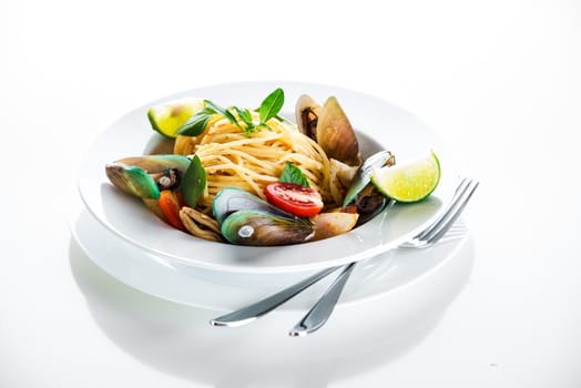 Fresh and spicy seafood pasta in white plate on white background