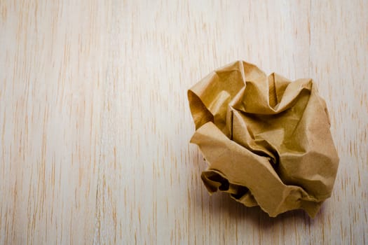 brown paper ball isolated on wood background
