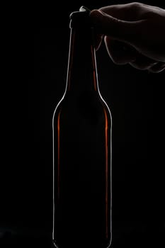 beer bottle open hand black background 