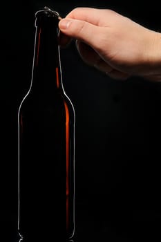 Open bottle beer hand black background brown