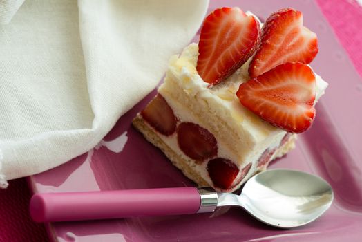 Dessert - sweet strawberry cake on pink plate and white napkin