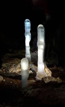 Luminescent ice stalagmites in the cave.