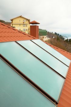 Solar water heating system (geliosystem) on the red house roof.