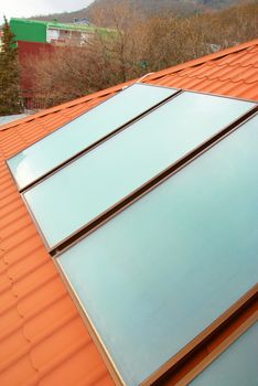 Solar water heating system (geliosystem) on the red house roof.