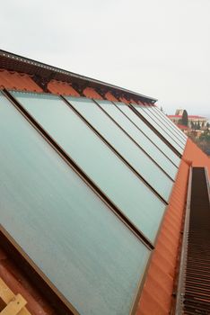 Solar water heating system (geliosystem) on the red house roof.