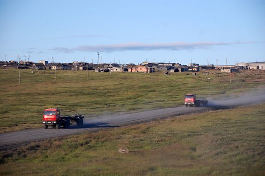 Trucks at gravel road abandoned town Chukotka, Russia