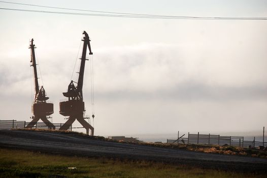 Gravel road near dockside cargo cranes at Pevek town, Chukotka, Russia