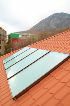 Solar water heating system (geliosystem) on the red house roof.